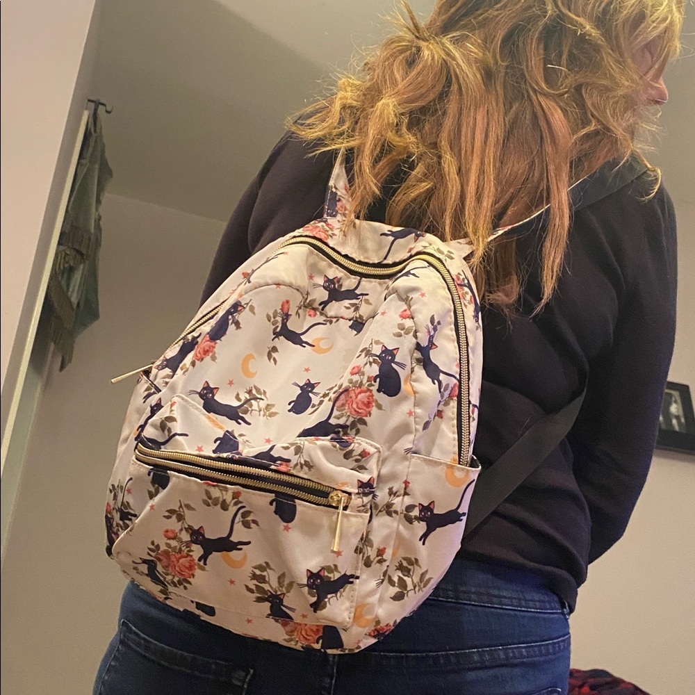 Enchanted cat theme vinyl backpack. Has many pockets and storage spaces.